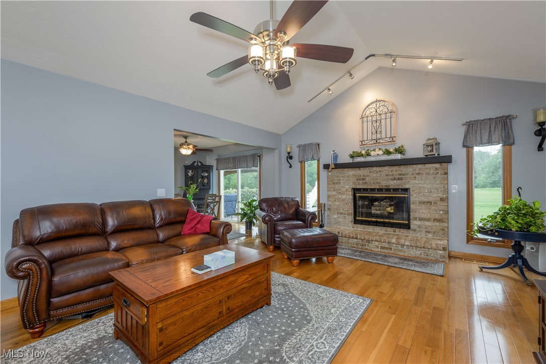 1435 Industry Road Atwater, OH 44201 - Photo 9 of 48 Living room featuring light hardwood floors, a healthy amount of sunlight, ceiling fan, and fireplace
