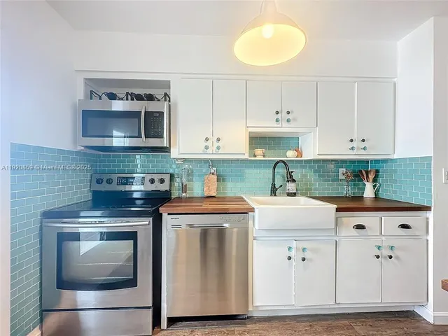 a kitchen with cabinets stainless steel appliances and a sink