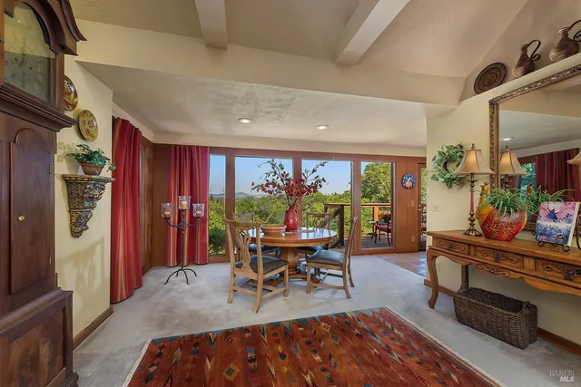 a living room with furniture a bookshelf and a window