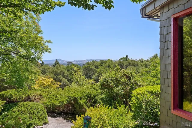 a view of a dining room with furniture a chandelier and large windows