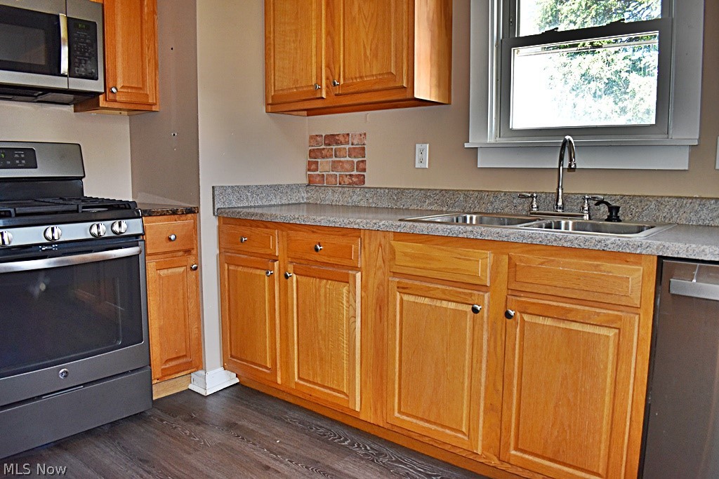 7715 Ackley Road Parma, OH 44129 - Photo 9 of 27 Kitchen with stainless steel appliances, dark wood-type flooring, and sink