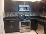 745 Falling Water Road Weston, FL 33326 - Photo 15 of 34 a kitchen with granite countertop a stove and a microwave