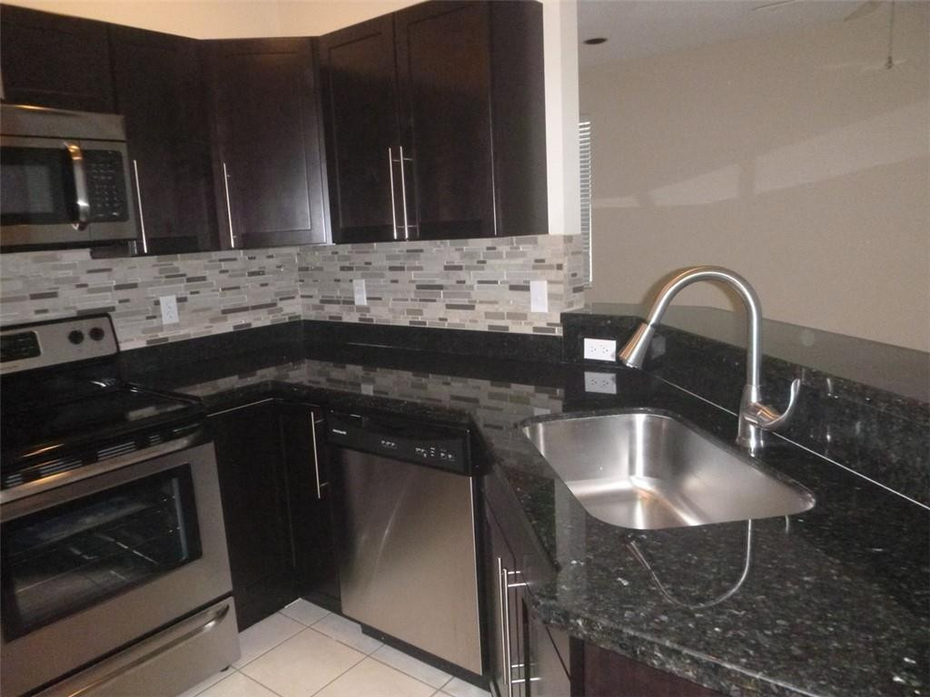 745 Falling Water Road Weston, FL 33326 - Photo 17 of 34 a kitchen with a sink stove and microwave