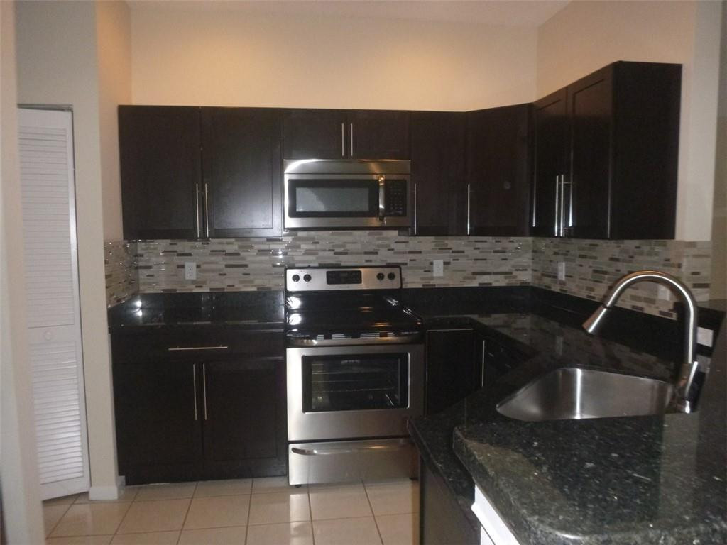 745 Falling Water Road Weston, FL 33326 - Photo 18 of 34 a kitchen with stainless steel appliances granite countertop a stove a sink and a microwave