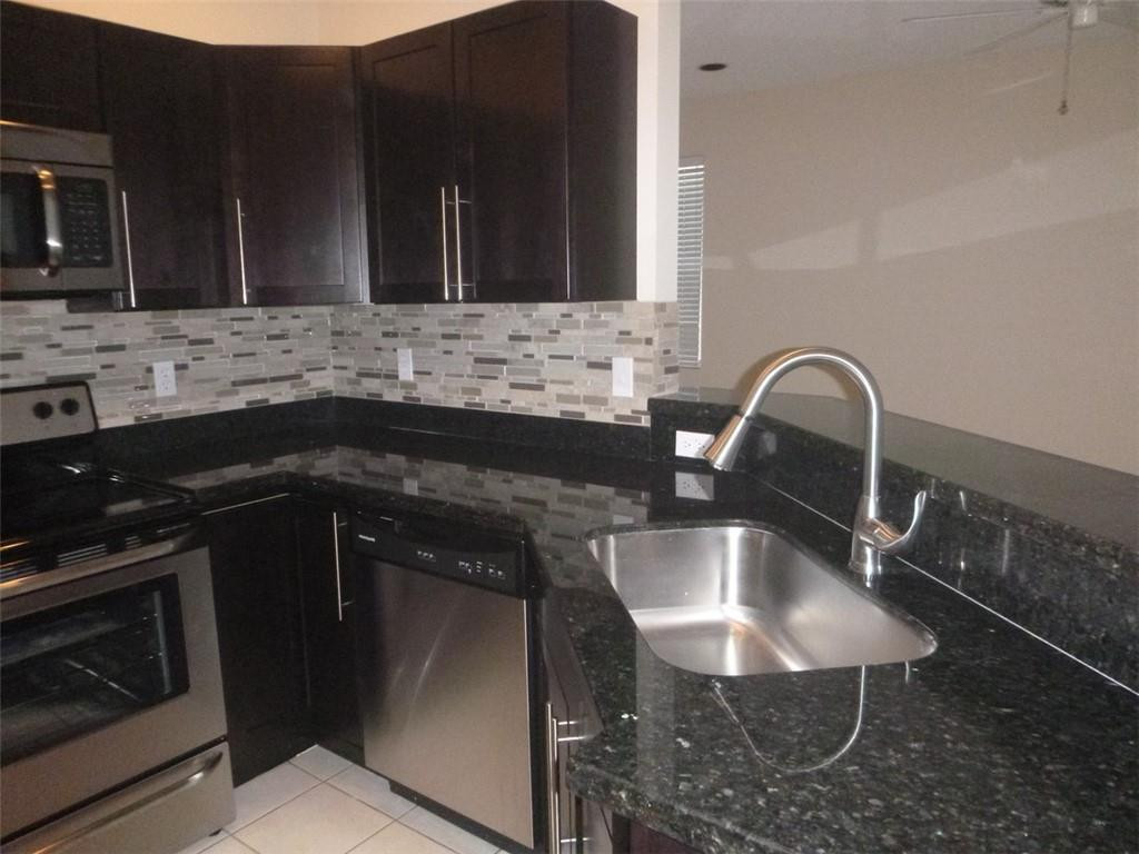 745 Falling Water Road Weston, FL 33326 - Photo 19 of 34 a close view of a sink and a stove in a kitchen