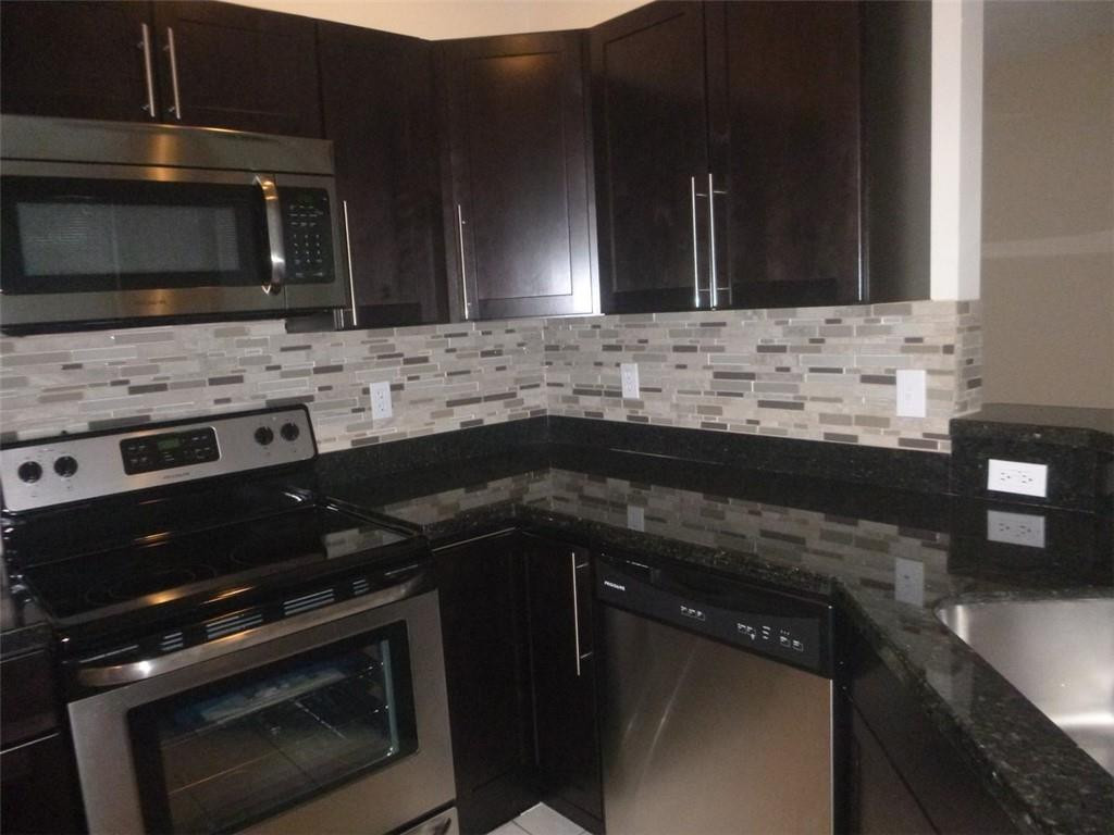 745 Falling Water Road Weston, FL 33326 - Photo 20 of 34 a kitchen with a sink stove and microwave