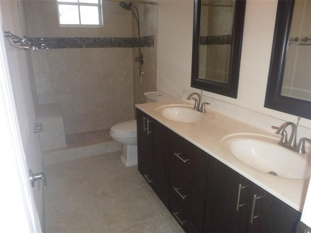 745 Falling Water Road Weston, FL 33326 - Photo 32 of 34 a bathroom with a double vanity sink toilet and a mirror