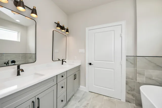 a bathroom with a double vanity sink a mirror and a shower