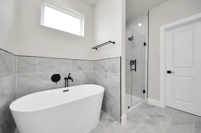 a white bath tub sitting next to a shower