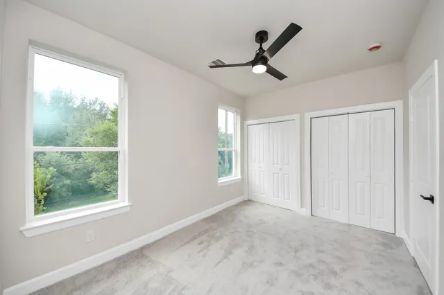 a view of an empty room and window ceiling fan