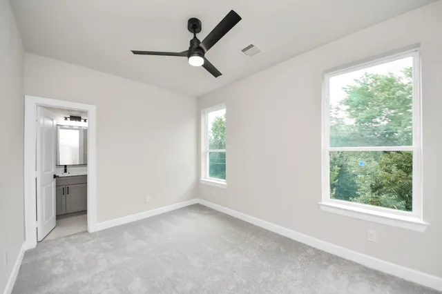 an empty room with a window and a ceiling fan