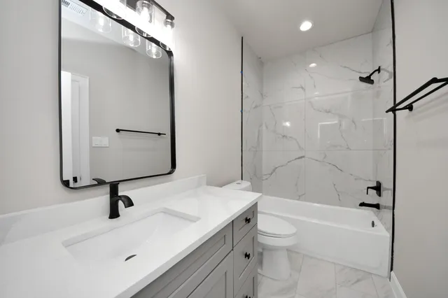 a bathroom with a sink a toilet and a large mirror