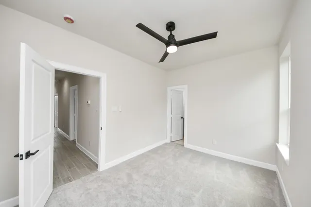 a view of a hallway with a ceiling fan