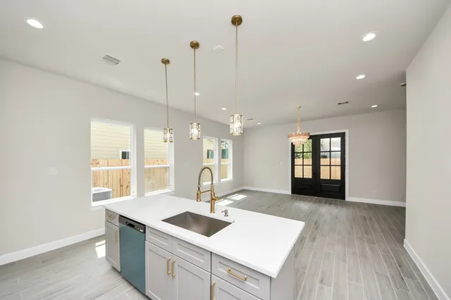 a kitchen with a sink a counter space appliances and cabinets