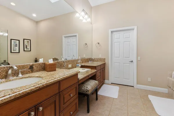 a bathroom with a granite countertop sink a toilet and a mirror