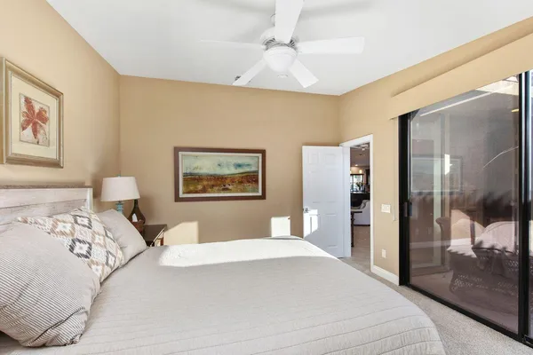 a bedroom with a large bed and a painting on the wall