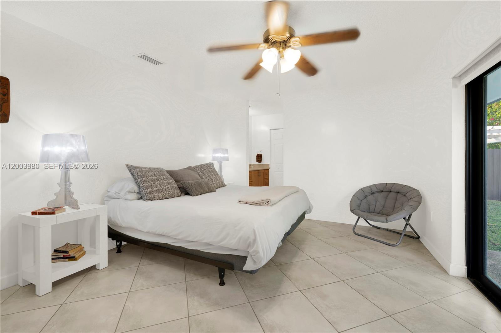 12221 Southwest 93rd Street Miami, FL 33186 - Photo 17 of 41 a bedroom with a bed and a chandelier