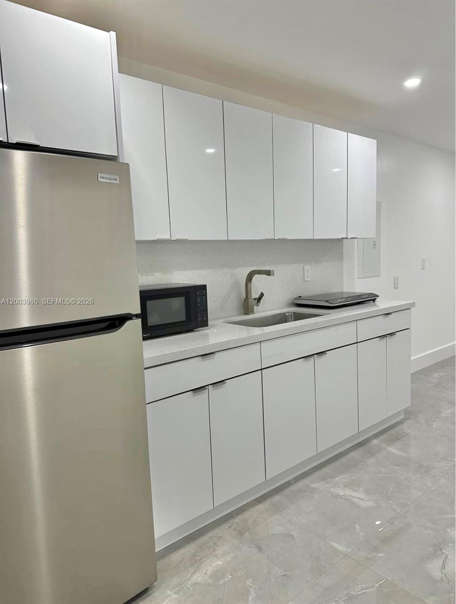 12221 Southwest 93rd Street Miami, FL 33186 - Photo 39 of 41 a kitchen with stainless steel appliances white cabinets and a refrigerator