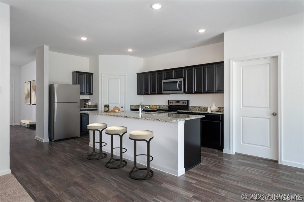 3527 Fernanda Drive Deltona, FL 32738 - Photo 3 of 9 a kitchen with stainless steel appliances granite countertop a refrigerator stove microwave and sink