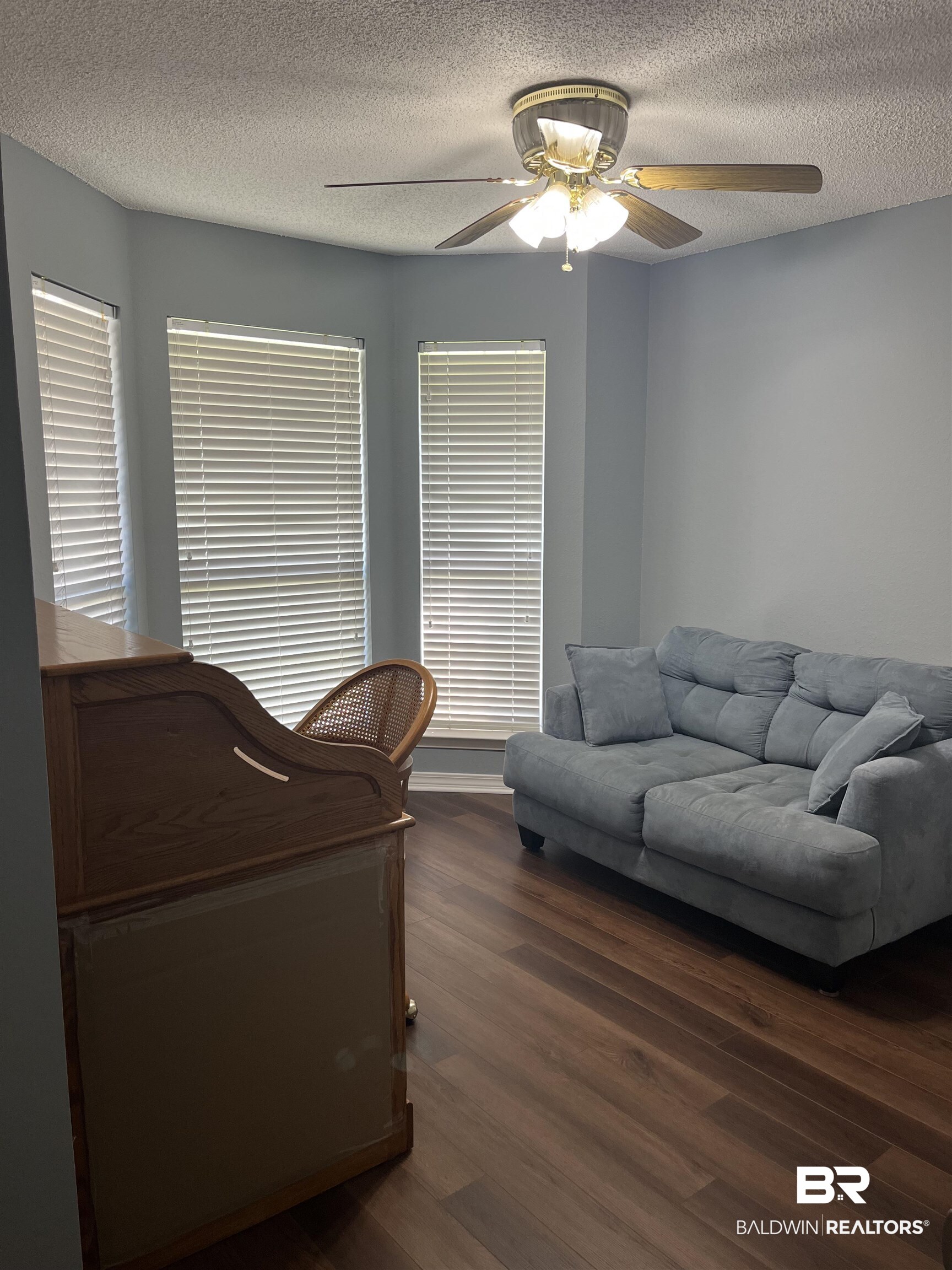 309 Cluster Street Foley, AL 36535 - Photo 23 of 38 Room featuring a bay window with blinds, wood-finish flooring, and a ceiling fan with integrated lighting
