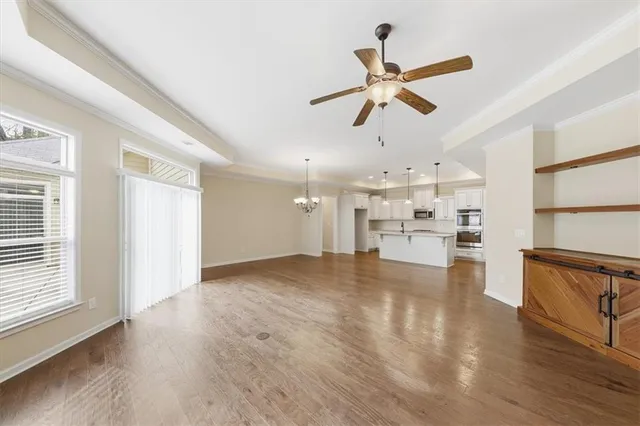 a view of an empty room with wooden floor fireplace and a window