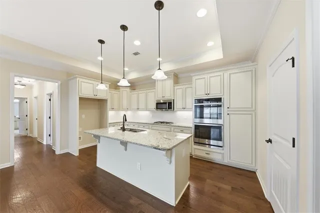 a kitchen with granite countertop white cabinets and stainless steel appliances