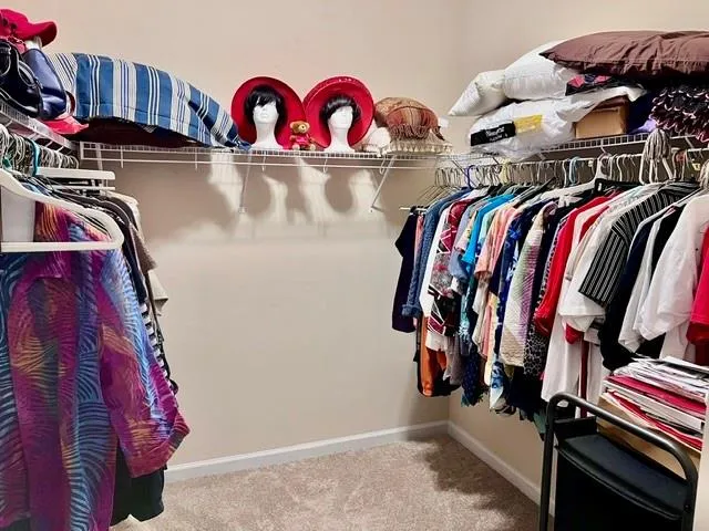 a view of walk in closet with clothes