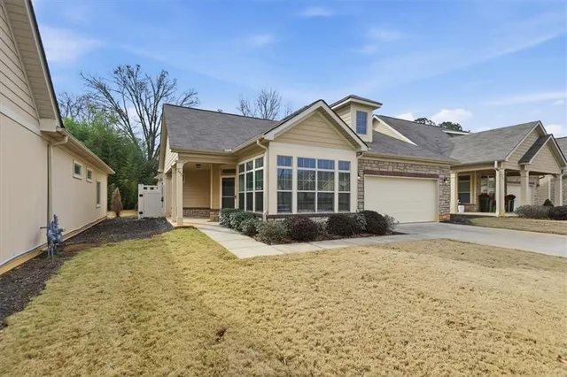 a view of a house with a yard and large tree