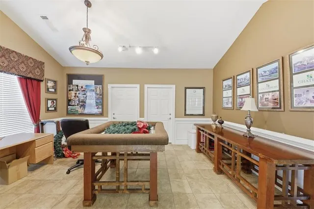 a view of a dining room and livingroom with furniture wooden floor a chandelier