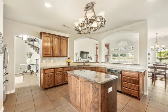 a kitchen with a sink counter top space appliances and a chandelier