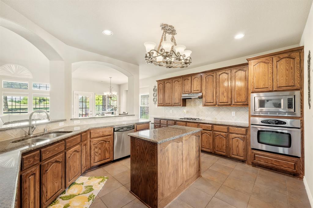 10601 Huffines Drive Rowlett, TX 75089 - Photo 12 of 29 a kitchen with stainless steel appliances granite countertop wooden cabinets and a sink