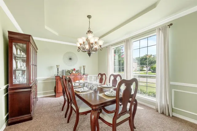 a dining room with furniture a chandelier and a rug