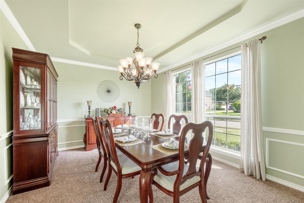 10601 Huffines Drive Rowlett, TX 75089 - Photo 13 of 29 a dining room with furniture a chandelier and a rug