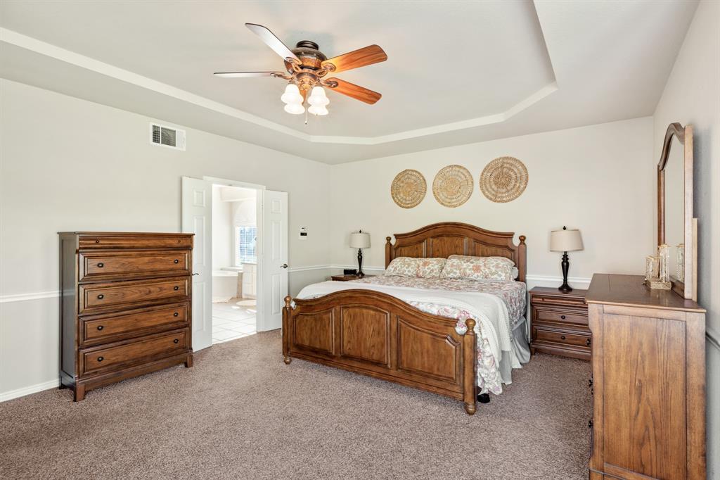 10601 Huffines Drive Rowlett, TX 75089 - Photo 15 of 29 a bedroom with a bed and a chandelier