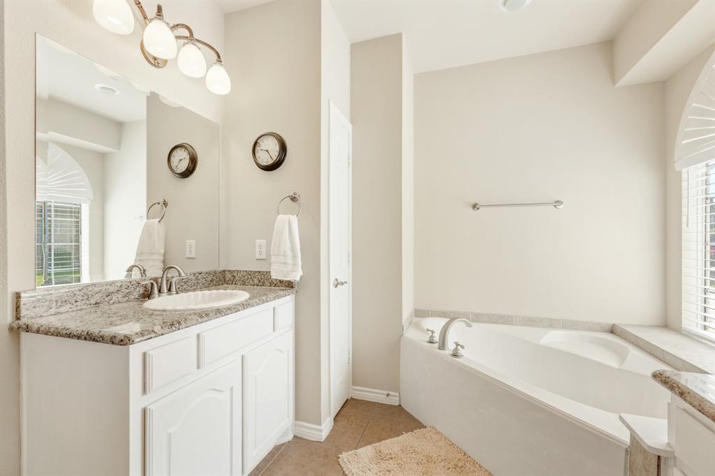 10601 Huffines Drive Rowlett, TX 75089 - Photo 17 of 29 a bathroom with a granite countertop sink and a mirror