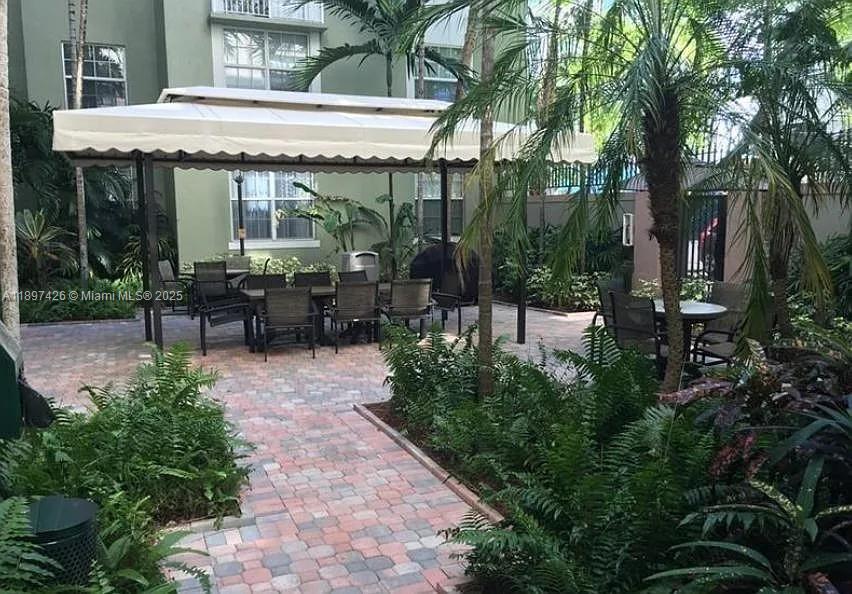 1919 Van Buren Street, Unit 719A Hollywood, FL 33020 - Photo 12 of 17 a view of a patio with table and chairs potted plants and large tree
