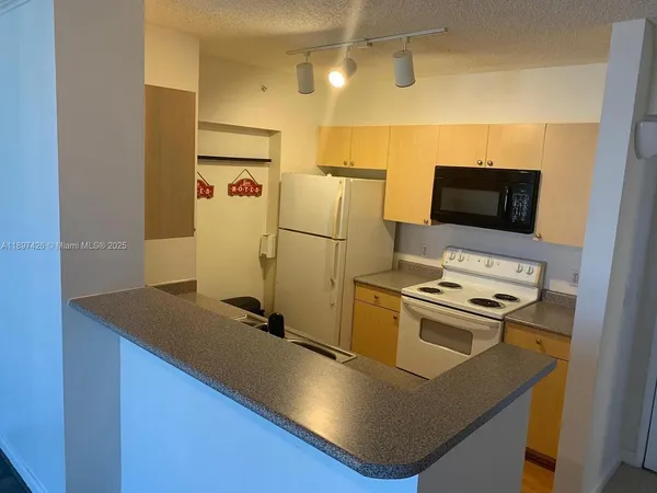 a kitchen with stainless steel appliances granite countertop a sink a stove and a refrigerator