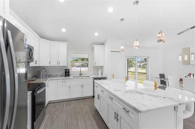 a kitchen with a sink stove cabinets and refrigerator