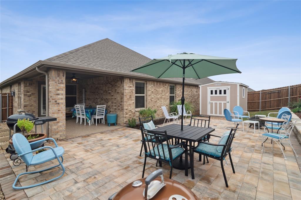 113 Lantern Road Caddo Mills, TX 75135 - Photo 2 of 25 a view of a patio with a table and chairs under an umbrella