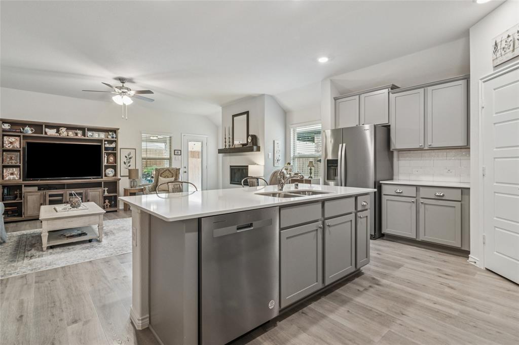 113 Lantern Road Caddo Mills, TX 75135 - Photo 6 of 25 a kitchen with stainless steel appliances a sink a stove a refrigerator cabinets and a living room