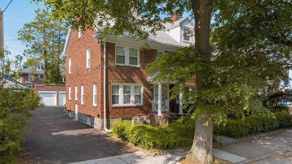 45 Pershing Road Boston, MA 02130 - Photo 23 of 29 a view of a brick house with a large tree