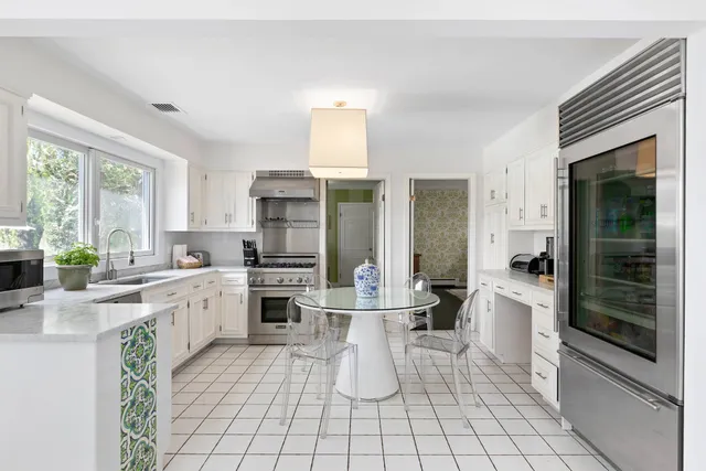 a large white kitchen with cabinets and furniture