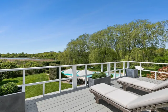 a view of a balcony with wooden floor and yard