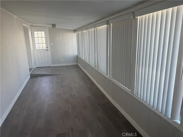 a view of a hallway with wooden floor and windows