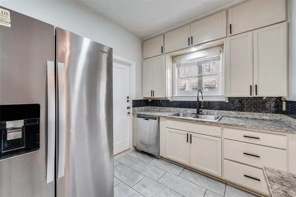 a kitchen with stainless steel appliances granite countertop a refrigerator and a sink