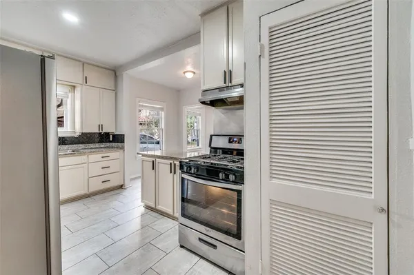 a kitchen with white cabinets and white appliances