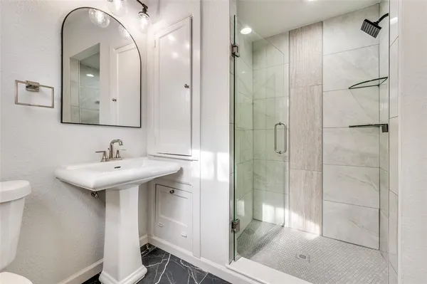 a bathroom with a sink a toilet and shower