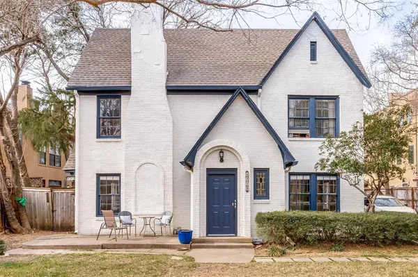 a view of a house with brick walls and a yard with plants