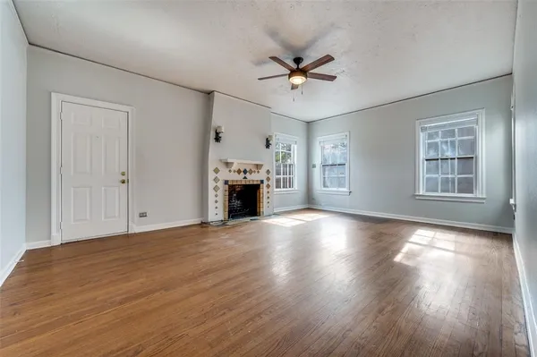 a view of empty room with wooden floor and fireplace