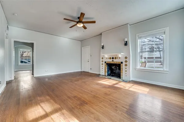 a view of an empty room with a window and fireplace